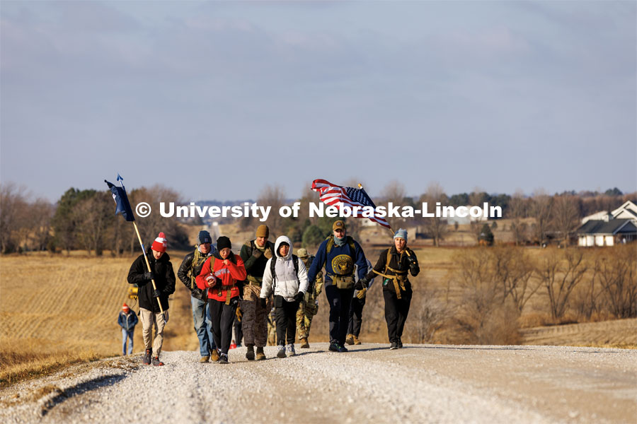 Ruck Marchers walk along Holdrege Street in rural eastern Lancaster County. Nebraska students and veterans march from Memorial Stadium Wednesday morning. "The Things They Carry" ruck march involving military and veteran students from Iowa and Nebraska. To raise awareness about veteran suicide, through the week, the students walk in 20-mile shifts carrying 20-pound backpacks to commemorate the estimated 20 veterans who die by suicide each day. November 15, 2022. Photo by Craig Chandler / University Communication.