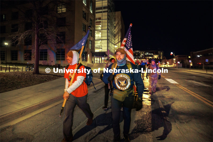 Midshipman Cohan Bonow, right, and UNL alumni and veteran Connor Williams trek along Vine Street with fellow Ruck Marchers. Nebraska students and veterans march from Memorial Stadium Wednesday morning. "The Things They Carry" ruck march involving military and veteran students from Iowa and Nebraska. To raise awareness about veteran suicide, through the week, the students walk in 20-mile shifts carrying 20-pound backpacks to commemorate the estimated 20 veterans who die by suicide each day. November 15, 2022. Photo by Craig Chandler / University Communication.