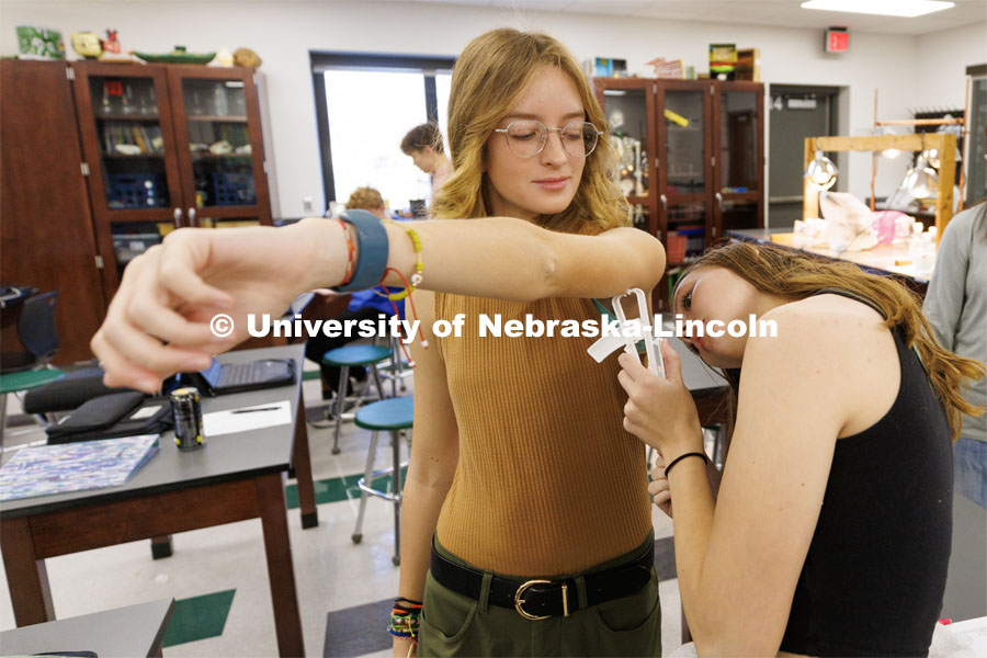 Sara Musil measures a skin flap on Kit Brooks at one of the measuring stations Friday morning. Chelle Gillan and her Central City class are studying anthropometric differences around the globe Gillan spent time this summer in Kenya gathering physical data there so students in her Advanced Biology classes could compare and do research. November 18, 2022. Photo by Craig Chandler / University Communication.