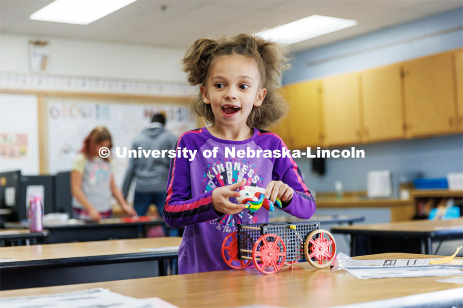 A student adds a unicorn squishy to decorate her car. Nebraska honors students Spencer Knight (blue shirt) and Rohan Tatineni (glasses) work with Riley Elementary students in their after-school STEM club. November 22, 2022. Photo by Craig Chandler / University Communication.