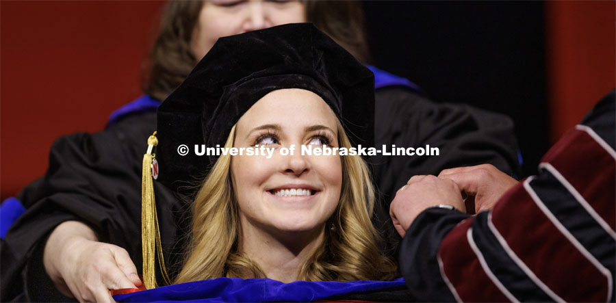 Haley Beer smiles as she receives her hood. Graduate Commencement in Pinnacle Bank Arena. December 16, 2022. Photo by Craig Chandler / University Communication.