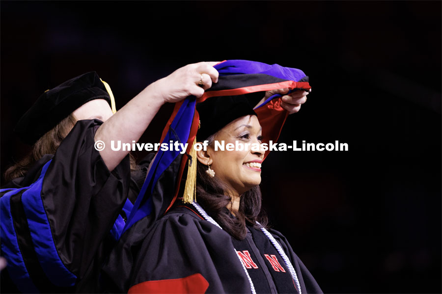 Marianna Burks smiles as she receives her hood. Graduate Commencement in Pinnacle Bank Arena. December 16, 2022. Photo by Craig Chandler / University Communication.