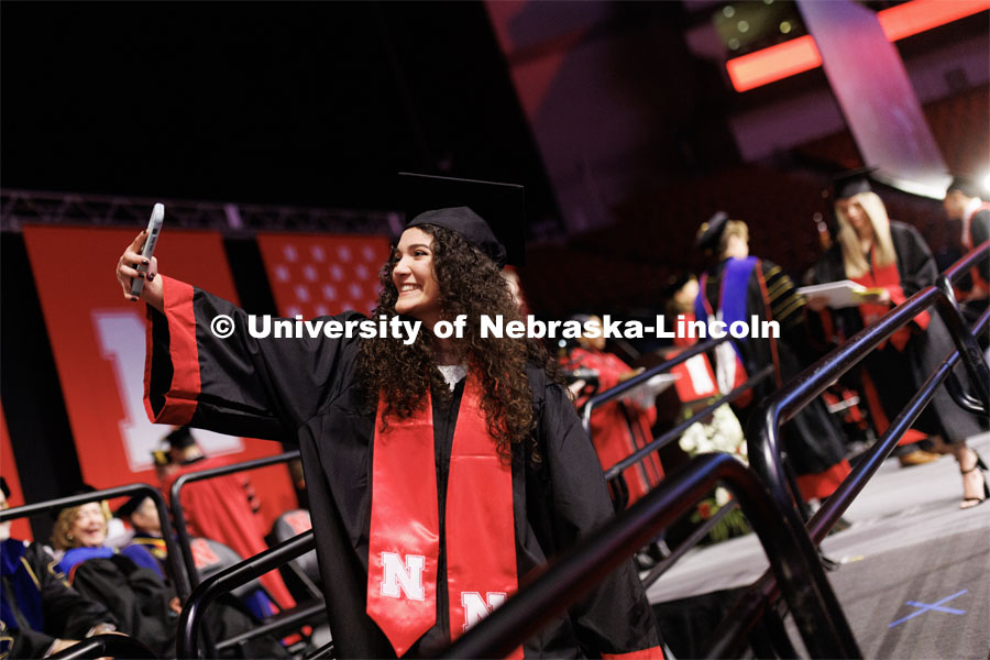Ariel Zavala, a graduate in Animal Science, takes a selfie as she walks off stage. Winter Undergraduate Commencement in Pinnacle Bank Arena. December 17, 2022. Photo by Craig Chandler / University Communication.