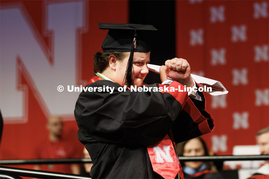 College of Business Management graduate Zachary Molzer gestures for the live-stream cameras. Winter Undergraduate Commencement in Pinnacle Bank Arena. December 17, 2022. Photo by Craig Chandler / University Communication.