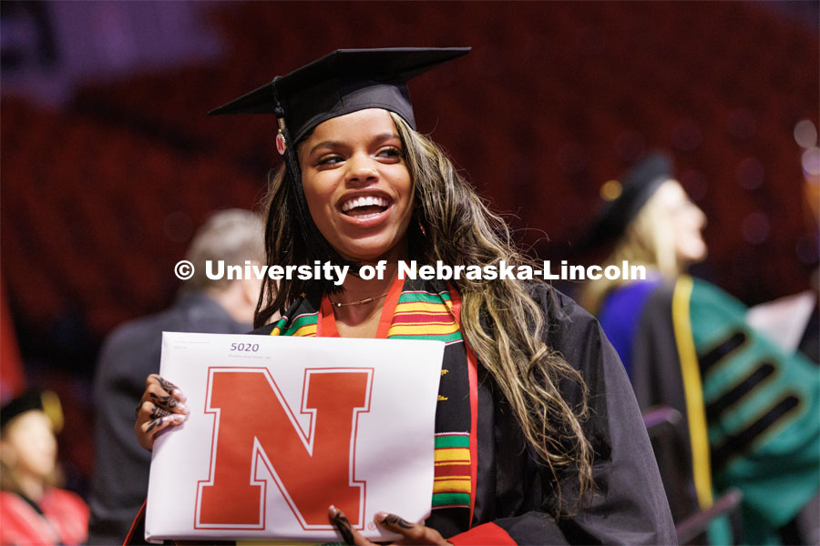 Bouthaina Ibrahim smiles to family and friends after receiving her Journalism and Mass Communication diploma. Winter Undergraduate Commencement in Pinnacle Bank Arena. December 17, 2022. Photo by Craig Chandler / University Communication.
