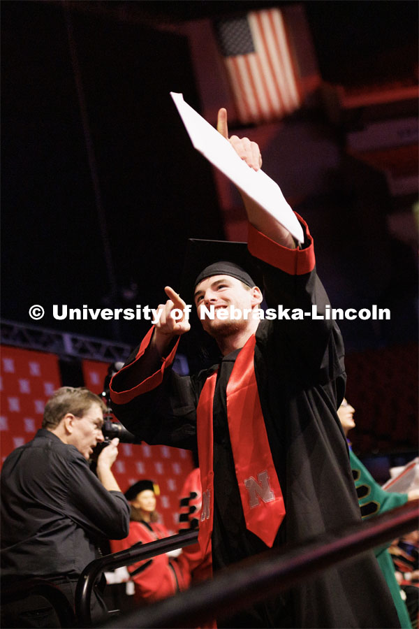 Advertising and Public Relations graduate Clark Stelter points to family and friends after receiving his diploma. Winter Undergraduate Commencement in Pinnacle Bank Arena. December 17, 2022. Photo by Craig Chandler / University Communication.
