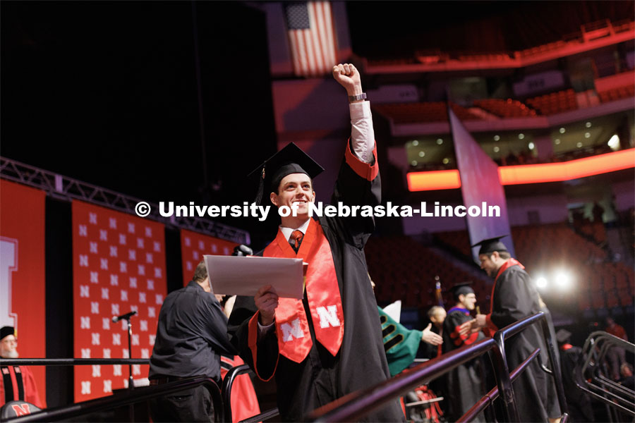 Ryan Yetts, a graduate in Sports Media and Communication, waves to family and friends. Winter Undergraduate Commencement in Pinnacle Bank Arena. December 17, 2022. Photo by Craig Chandler / University Communication.