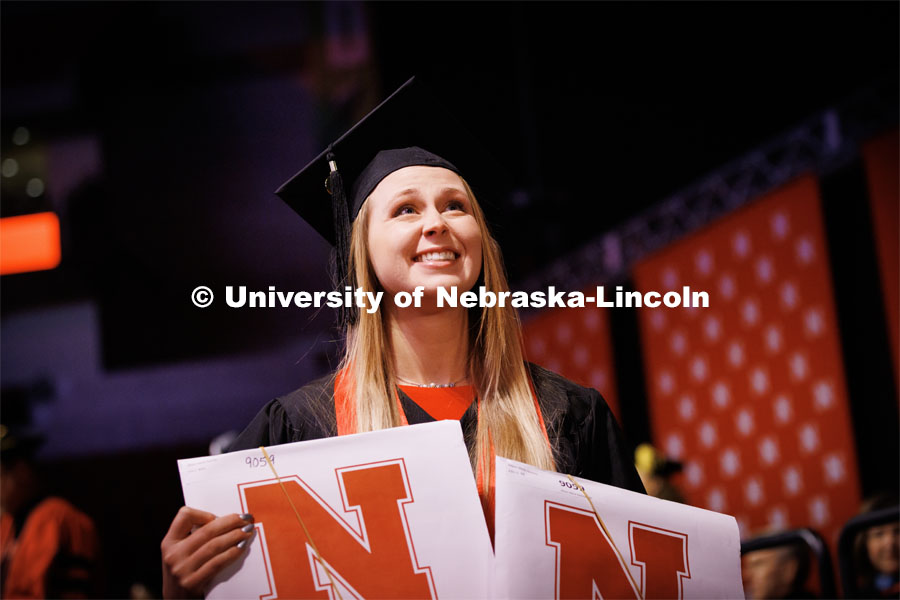 Allison Hinrichs holds her diplomas up for family and friends. Winter Undergraduate Commencement in Pinnacle Bank Arena. December 17, 2022. Photo by Craig Chandler / University Communication.