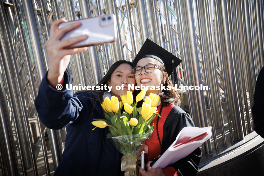 Bobbi Le, a Psychology graduate, and Tina Dinh take a selfie after commencement. Winter Undergraduate Commencement in Pinnacle Bank Arena. December 17, 2022. Photo by Craig Chandler / University Communication.