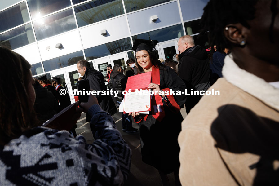 Sofia Gutierrez, a graduate in Textile, Merchandising and Fashion Design, was in the spotlight as friends and family photographed her and her diploma in the sunshine Saturday morning following commencement. Winter Undergraduate Commencement in Pinnacle Bank Arena. December 17, 2022. Photo by Craig Chandler / University Communication.