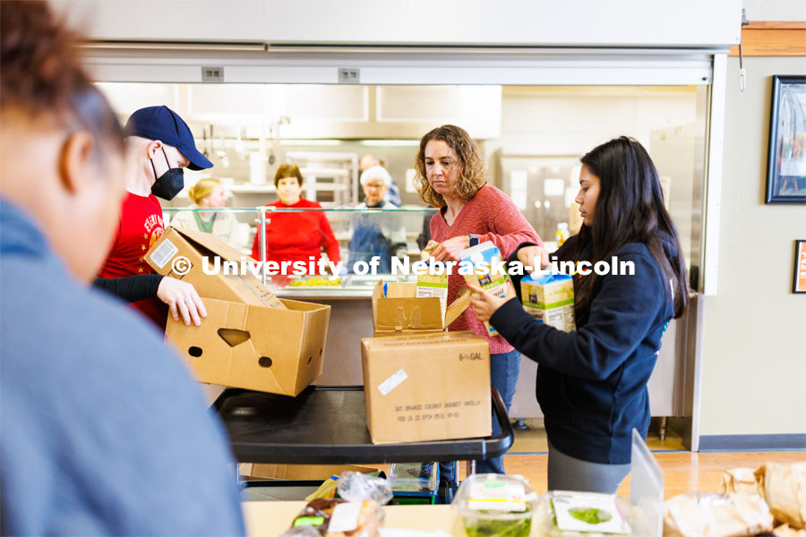 Rev. Zac Wolfe, left, Rebecca Baskerville, Associate Director for Experiential and Global Learning, and Bree Bell, a freshman in marketing from Omaha, unload food for the lunch crowd at Matt Talbot. Nebraska University volunteers Tuesday at Matt Talbot. January 24, 2023. Photo by Craig Chandler / University Communication.