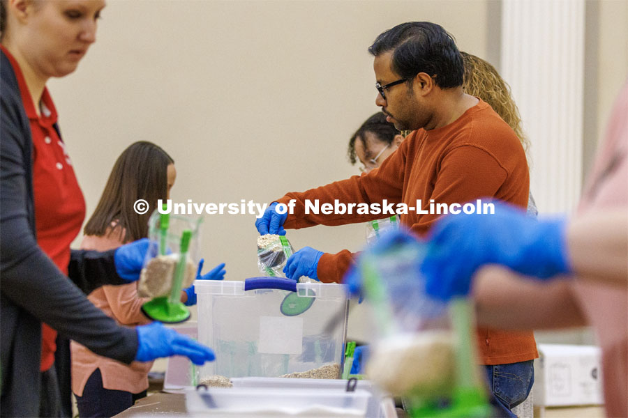 Malakar Arindam, Research Assistant Professor with the Nebraska Water Center, scoops oatmeal into bags as part of MLK Week events. Volunteers assemble hunger kits filled with oatmeal. The goal was more than 2,000 kits. January 25, 2023. Photo by Craig Chandler / University Communication.