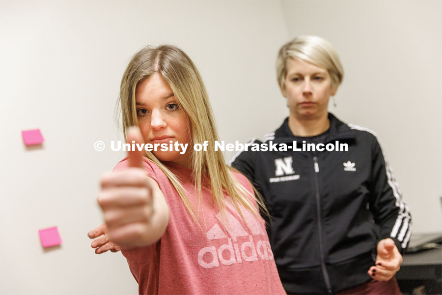Dr. Kate Higgins, an Athletic Neuropsychologist with Husker Athletics, performs a Visual Motion Sensitivity task during Vestibular Ocular Motor Screening on mock patient Makayla Burchett, a freshman from Harlan, Iowa. Burchett holds her thumb out and rotates left and right while moving her head to follow the thumb. The University Health Center and Nebraska Medicine recently moved its concussion clinic to the Nebraska Performance Lab in the east stadium space. February 1, 2023. Photo by Craig Chandler / University Communication.