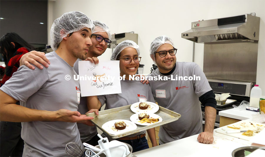 Kevin Lievano, David Fabian Gomez Quintero, Carmen Perez-Donado and Armando Lerma Fuentes take a quick photo with their plated Crick Crick Brownie before presenting to judges. Groups prepared baked goods using flour made from crickets. Battle of the Food Scientists at Nebraska Innovation Campus. February 15, 2023. Photo by Blaney Dreifurst / University Communication.