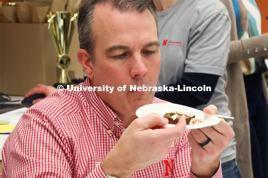 Contest judge Terry Howell with the UNL Food Processing Center gives an entry a close eye as he prepares for a taste. Groups prepared baked goods using flour made from crickets. Battle of the Food Scientists at Nebraska Innovation Campus. February 15, 2023. Photo by Blaney Dreifurst / University Communication.