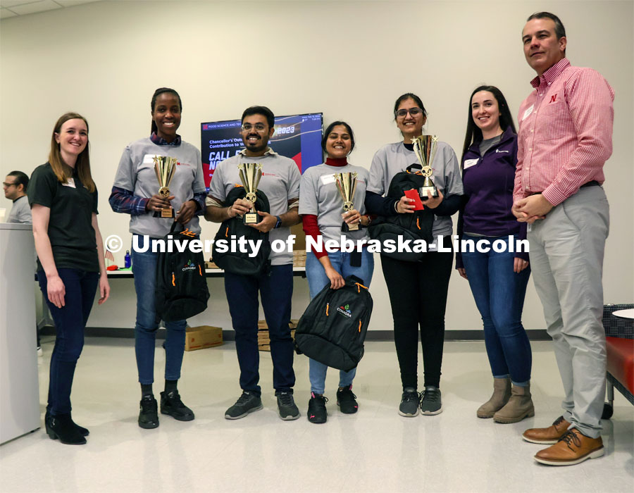 The winning team takes a photo with the competition judges. Pictured are (from left) Nicolle Kaliff, Sedoten Ogun, Prabhashis Bose, Sayantini Paul, Urvinder Kaur Sardarni, Ava Petersen and Terry Howell. Groups prepared baked goods using flour made from crickets. Battle of the Food Scientists at Nebraska Innovation Campus. February 15, 2023. Photo by Blaney Dreifurst / University Communication.