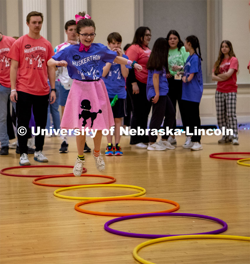 Parker Matzen hops through hulahoops at the 2023 HuskerThon. University of Nebraska–Lincoln students raised $118,208 during the annual HuskerThon on Feb. 25. Also known as Dance Marathon, the event is part of a nationwide fundraiser supporting Children’s Miracle Network Hospitals. The annual event, which launched in 2006, is the largest student philanthropic event on campus. The mission of the event encourages participants to, “dance for those who can’t.” All funds collected by the Huskers benefit the Children’s Hospital and Medical Center in Omaha. February 25, 2023. Photo by Blaney Dreifurst for University Communication.