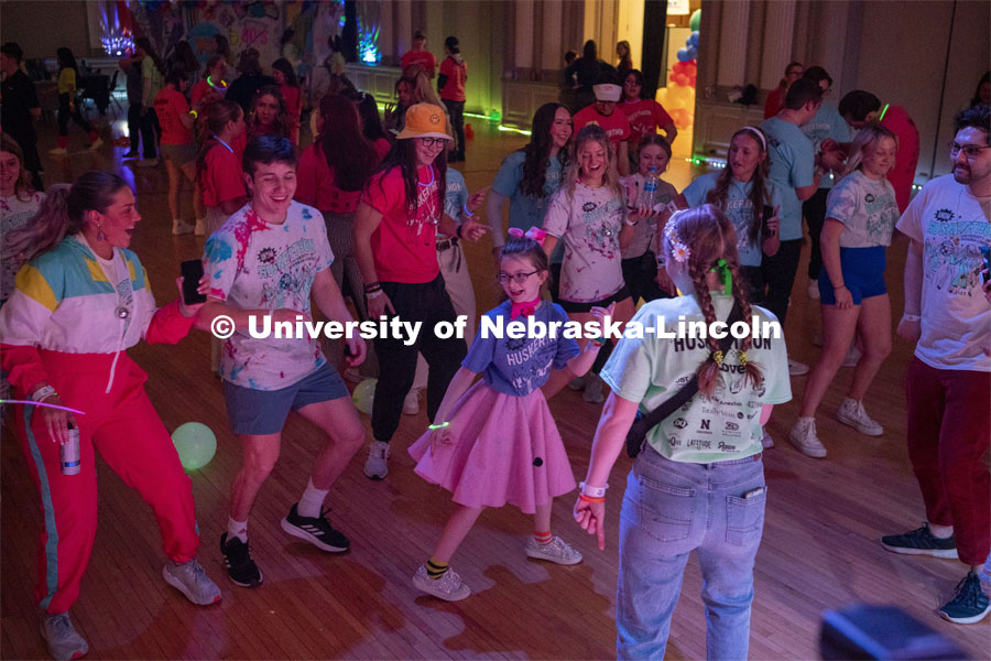 Parker Matzen leads a group of students in a dance during the 70s disco dance party portion of Huskerthon. University of Nebraska–Lincoln students raised $118,208 during the annual HuskerThon on Feb. 25. Also known as Dance Marathon, the event is part of a nationwide fundraiser supporting Children’s Miracle Network Hospitals. The annual event, which launched in 2006, is the largest student philanthropic event on campus. The mission of the event encourages participants to, “dance for those who can’t.” All funds collected by the Huskers benefit the Children’s Hospital and Medical Center in Omaha. February 25, 2023. Photo by Blaney Dreifurst for University Communication.