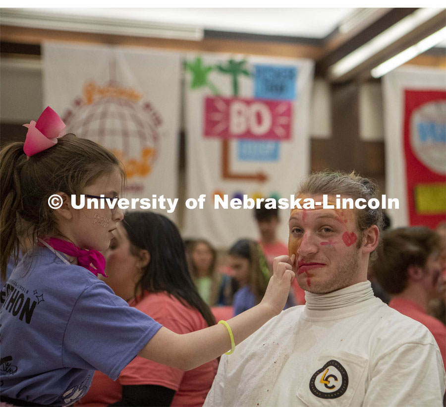 Sam DeZube gets his makeup done by Parker Malzen before performing with his band, Loose Change, during Huskerthon. University of Nebraska–Lincoln students raised $118,208 during the annual HuskerThon on Feb. 25. Also known as Dance Marathon, the event is part of a nationwide fundraiser supporting Children’s Miracle Network Hospitals. The annual event, which launched in 2006, is the largest student philanthropic event on campus. The mission of the event encourages participants to, “dance for those who can’t.” All funds collected by the Huskers benefit the Children’s Hospital and Medical Center in Omaha. February 25, 2023. Photo by Blaney Dreifurst for University Communication.