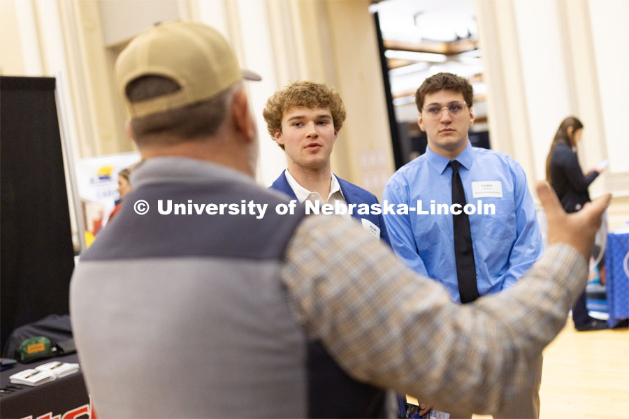 Jonah Harrison, left, and Lewis Ziemba talk with recruiters from Crop Quest during the first day of the Career and Internship Fair in Nebraksa Union. February 27, 2023. Photo by Craig Chandler / University Communication.