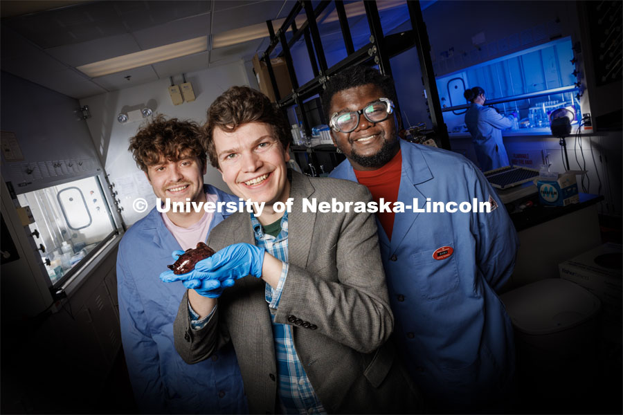 Nebraska chemists James Checco (center), Baba Yussif (right) and Cole Blasing have found that a natural, ultra-minor alteration to a molecule can dictate which neuron receptors a neurotransmitter will activate. The team discovered the phenomenon in a species of sea slug being held by Checco, though the findings should apply to a range of animals — potentially even humans. March 9, 2023. Photo by Craig Chandler / University Communication.
