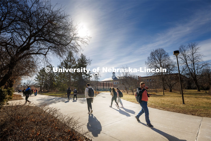 Students cross campus near the Love Library on their first day on campus following spring break. March 20, 2023. Photo by Craig Chandler / University Communication. 