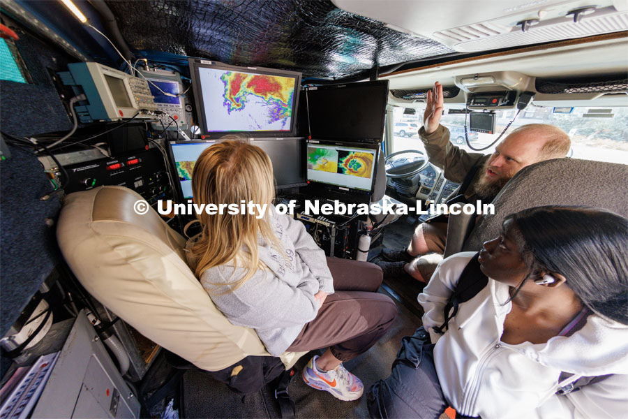 Josh Aikins of the University of Illinois’ Flexible Array of Radars and Mesonets, explains the workings of the radar truck to Husker sophomore Hope Cumming (left), and junior Jacquie Paul (bottom). The Doppler on Wheels, part of the Flexible Array of Radars and Mesonets operated by the University of Illinois, is on campus this week so Adam Houston’s TORUS team can train with it. The DOW is also being demonstrated to the meteorology students. March 20, 2023. Photo by Craig Chandler / University Communication.