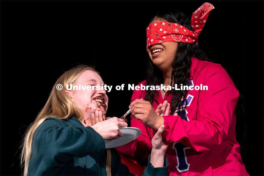 Ana Raymundo, right, feeds Abby Post pudding while being blindfolded during the OASIS and FRATERNITY AND SORORITY LIFE Stroll Off inside the Nebraska Union Centennial Room. April 1, 2023. Photo by Jordan Opp for University Communication.