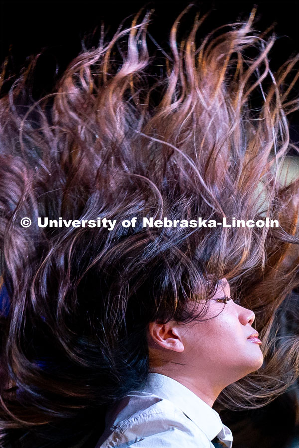 A member of Delta Phi Lambda flips their hair during the OASIS and FRATERNITY AND SORORITY LIFE Stroll Off inside the Nebraska Union Centennial Room. April 1, 2023. Photo by Jordan Opp for University Communication.