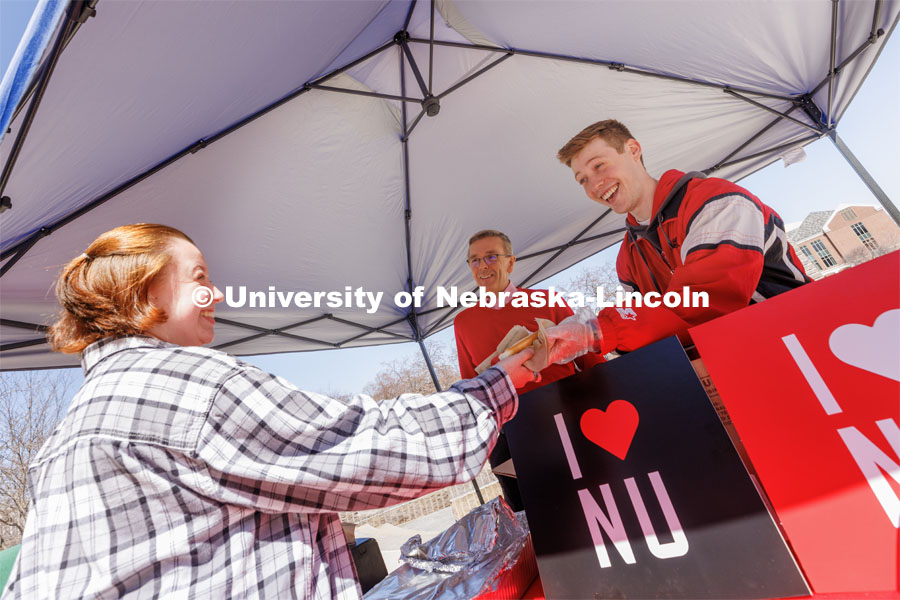 ASUN President and Student Regent Jacob Drake, right, and Chancellor Ronnie Green hand a hot dog to Marissa Hanley. I love UNL cookout sponsored by ASUN. April 4, 2023. Photo by Craig Chandler / University Communication.