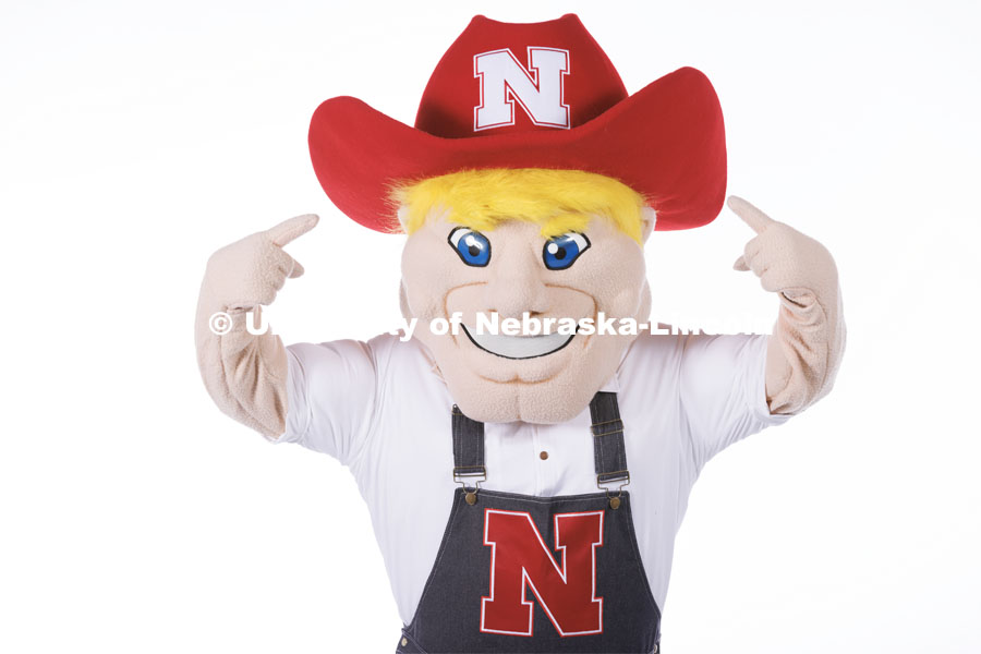 Studio portrait of Herbie pointing to the N on his hat. New Herbie photoshoot. April 7, 2023. Photo by Craig Chandler / University Communication.