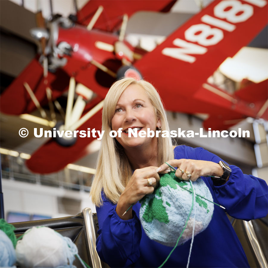 Nicole Sweigard is an avid knitter and traveler and usually knits while waiting on her flight. Sweigard is Associate Executive Director of Alumni Relations for Nebraska alumni. Globe kitted by Leslie Reed. Photo for Alumni magazine. April 12, 2023. Photo by Craig Chandler / University Communication.