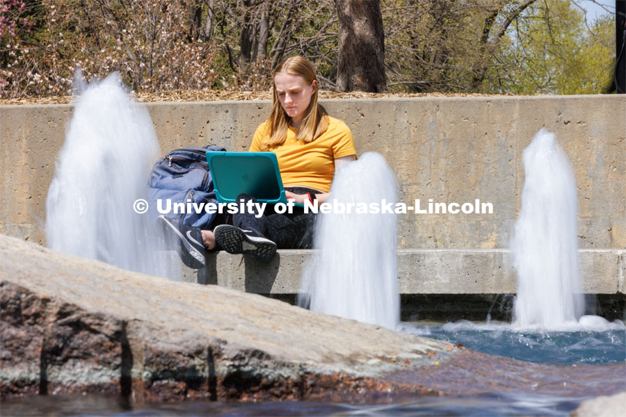 Anna James, a sophomore from Overland Park, Kansas, studies by Broyhill Fountain. Spring on City Campus. April 18, 2023. Photo by Craig Chandler / University Communication.