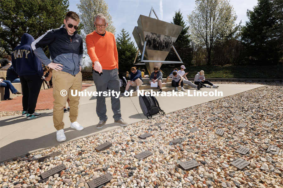Gerald Steinacher, professor of history, tells Nick Scholtes, a senior from Lincoln, the stories behind the memorial bricks. Each brick was engraved for a person murdered in the Holocaust with ties to Nebraska. History of the Holocaust course students visit the Holocaust memorial in Lincoln’s Wyuka Cemetery. April 18, 2023. Photo by Craig Chandler / University Communication.