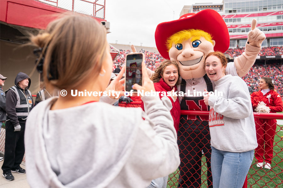 Sophomores Jaiden Davis, center, and Peyton Kullmann, right, take a photo with Herbie Husker during the spring game. April 22, 2023. Photo by Jordan Opp for University Communication.