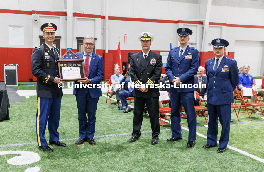 Chancellor Ronnie Green accepts a shadowbox from Lieutenant Colonel Mark Peer. left, along with Captain Orlando Bowman, Lieutenant Colonel Philip Garito and Colonel (Ret.) Joe Brownell. ROTC Joint Service Chancellor’s Review in Cook Pavilion. April 27, 2023. Photo by Craig Chandler / University Communication.