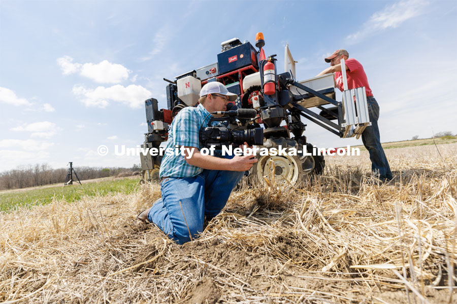 Bryce Doeschot, Market Journal and IANR Media, films the planting. The self-driving robotic planter based on Santosh Pitla’s tractor platform works its way through a field at the Rogers Memorial Farm east of Lincoln. April 27, 2023. Photo by Craig Chandler / University Communication.