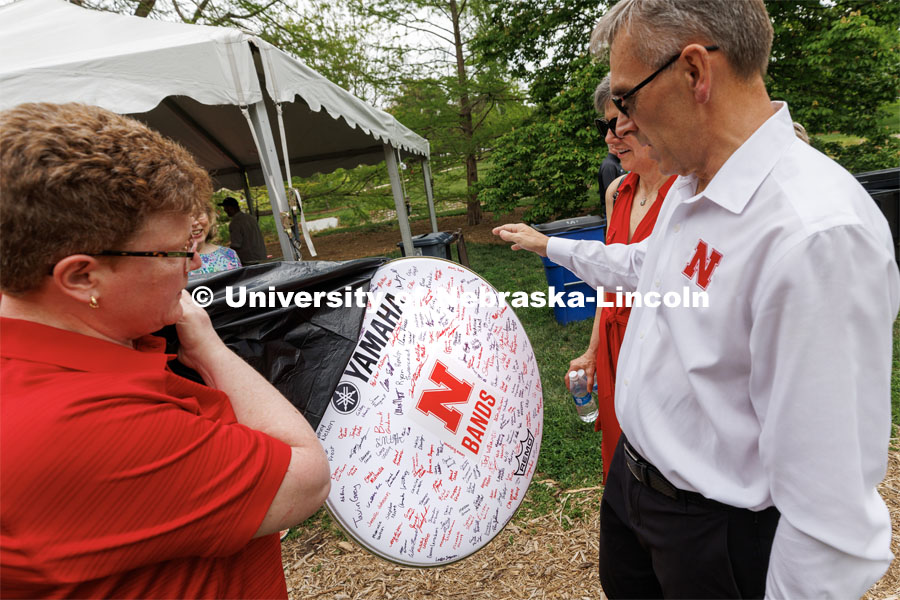 Carolyn Barber, Ron and Carol Cope Professor of Music and Director of Bands, presented the Greens with a drumhead signed by members of the Cornhusker Marching Band. Ronnie and Jane Green had an open house Thursday at the Maxwell Arboretum on East Campus. May 11, 2023. Photo by Craig Chandler / University Communication.