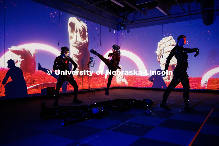 Students work in the Johnny Carson EMA MoCap (motion capture) lab wearing MoCap suits. The suits with their infrared sensors (round dots velcroed to the suit) allow a ring of cameras to turn their motion into animated characters on screen. May 17, 2023. Photo by Craig Chandler / University Communication.