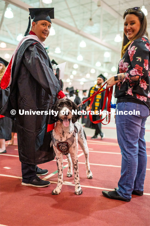 Grads pet Cash the K-9 police dog before the commencement ceremony. 2023 Spring Graduate Commencement in Bob Devaney Sports Center. May 19, 2023. Photo by Justin Mohling for University Communication.