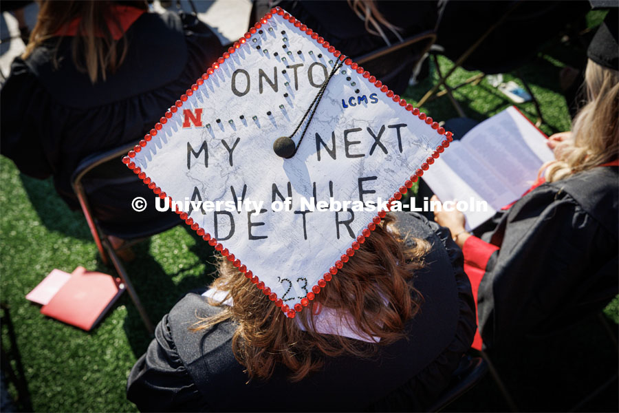 A decorated cap says, "Onto my next adventure". Undergraduate commencement at Memorial Stadium. May 20, 2023. Photo by Craig Chandler / University Communication.