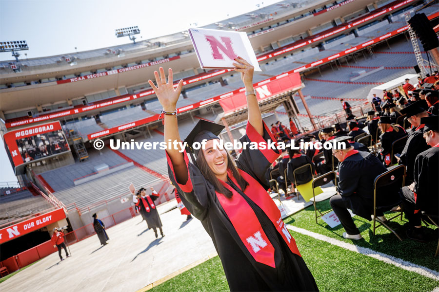 Isabel Adrover Gallego waves to family and friends after receiving her diploma. Undergraduate commencement at Memorial Stadium. May 20, 2023. Photo by Craig Chandler / University Communication.