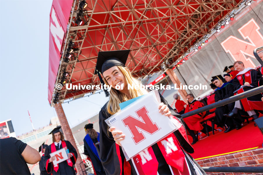 Haley Mercer walks off the stage with a smile and her diploma. Undergraduate commencement at Memorial Stadium. May 20, 2023. Photo by Craig Chandler / University Communication.