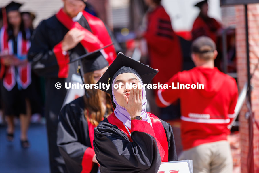 Grad blows a kiss. Undergraduate commencement at Memorial Stadium. May 20, 2023. Photo by Craig Chandler / University Communication.
