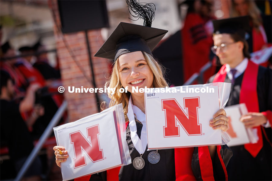 Lauren Frankforter shows her diplomas to the video cameras for the live broadcast of the ceremony. Undergraduate commencement at Memorial Stadium. May 20, 2023. Photo by Craig Chandler / University Communication.