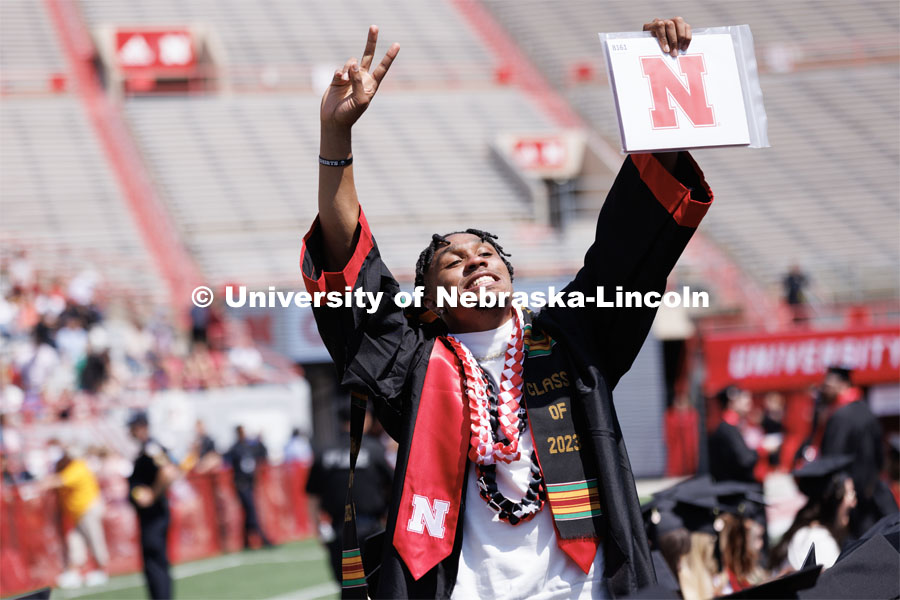 Javin Wright waves to family and friends after receiving his degree in sports media and communication. Undergraduate commencement at Memorial Stadium. May 20, 2023. Photo by Craig Chandler / University Communication.
