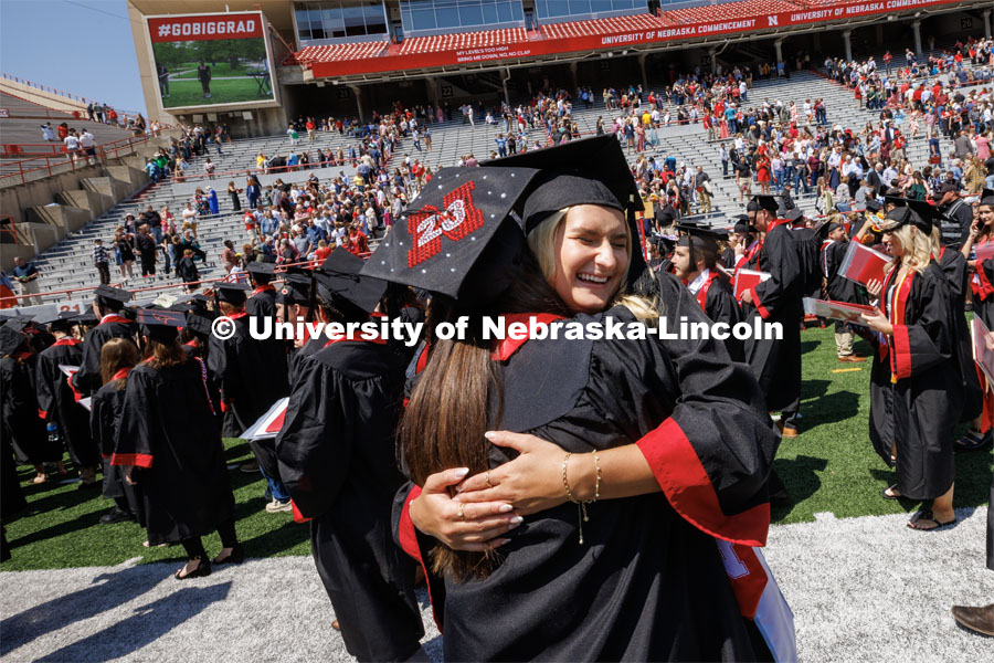 Jacqueline Wollschlaeger, right, hugs her friend, Ashley Oltman following commencement. Undergraduate commencement at Memorial Stadium. May 20, 2023. Photo by Craig Chandler / University Communication.