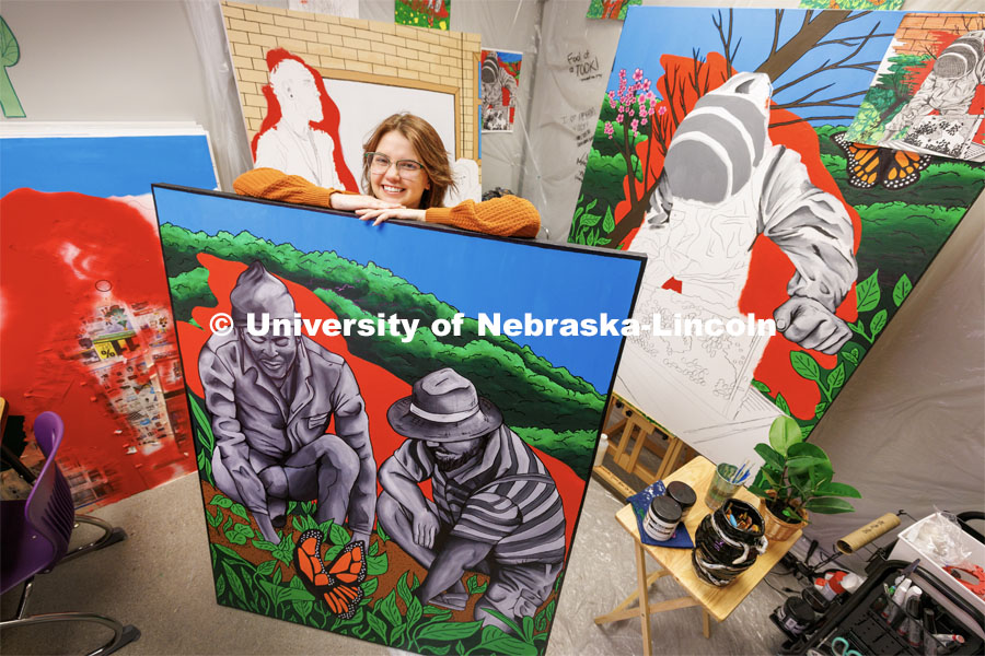 Peyton Miller poses with sections of a mural she and other students at Northeast High School are painting. Miller headed the creation of student murals saluting careers in food, energy, water and societal systems as part of Lincoln Northeast High School’s FEWSS partnership with the University of Nebraska–Lincoln. A room off of the library has been turned into an art studio to paint the mural which will hang in the library when completed. Miller graduated from Northeast this spring and will attend UNL in the fall pursuing an education degree. May 26, 2023. Photo by Craig Chandler / University Communication.