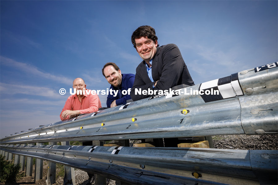 Husker Cody Stolle (right), Josh Steelman (center) and Ronald Faller lean against a guardrail developed at the university-housed Midwest Roadside Safety Facility that might be part of the solution to better protection for soldiers at military checkpoints. Cody Stolle, Research Assistant Professor and Assistant Director of the Midwest Roadside Safety Facility is leading a group researching better checkpoint barriers to help the Department of Defense. June 5, 2023. Photo by Craig Chandler / University Communication.