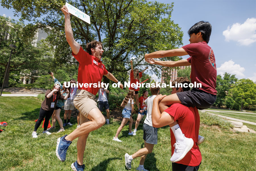 Chase Kavanaugh performs a faux slam dunk as his group does a “freeze frame” photo contest attempted by each group Wednesday. New Student Enrollment. June 7, 2023. Photo by Craig Chandler / University Communication.